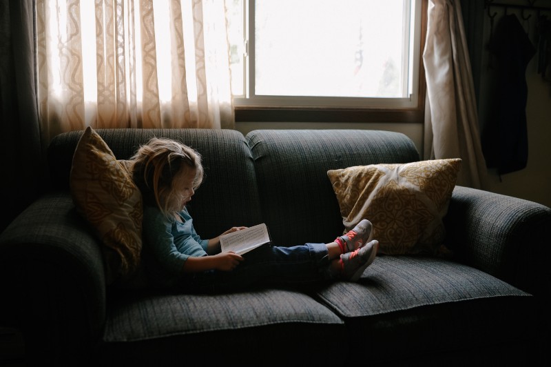 Child reading on a sofa