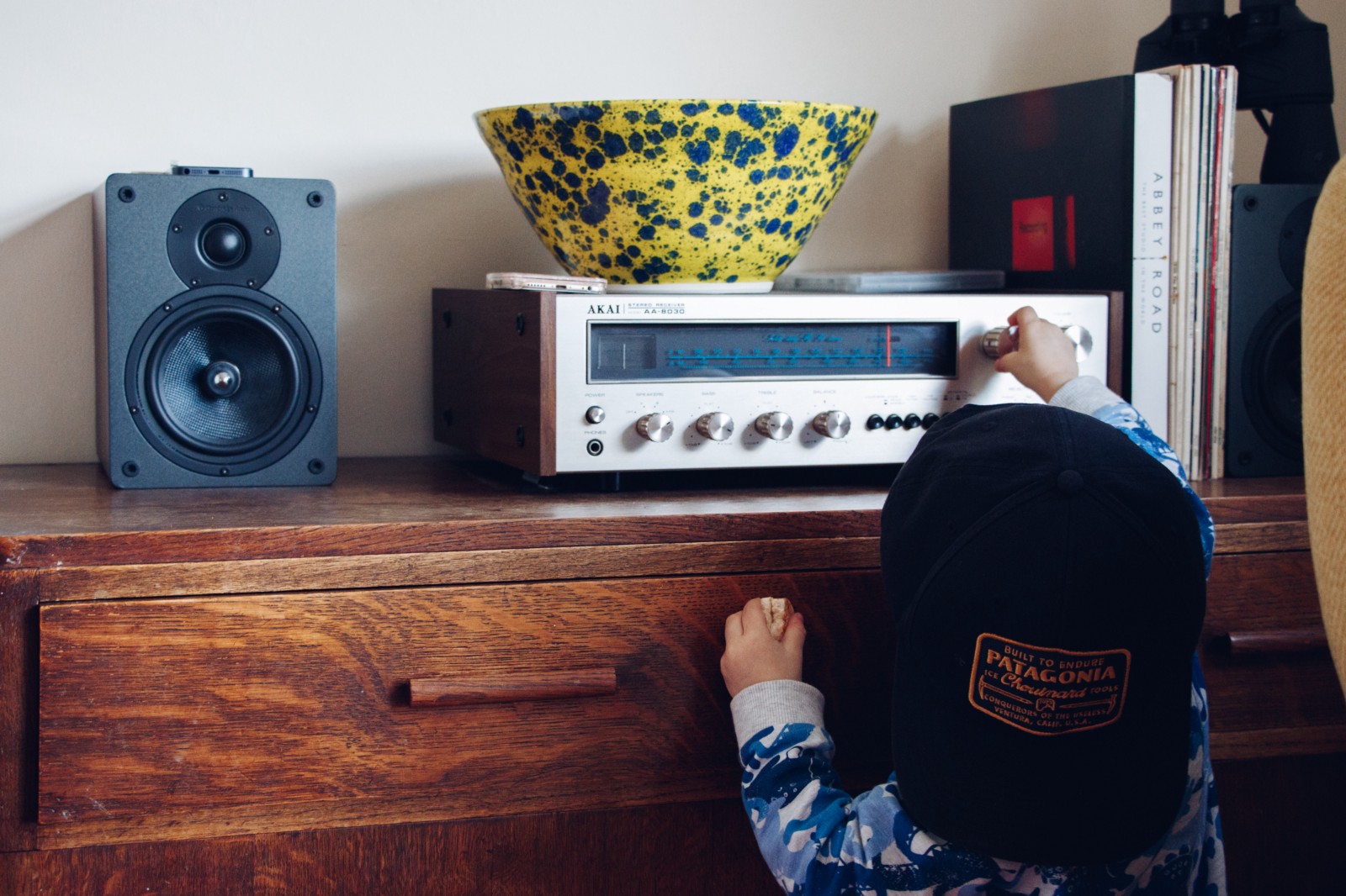 Child adjusting volume on old stereo tuner