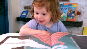 Excited young girl reading a book