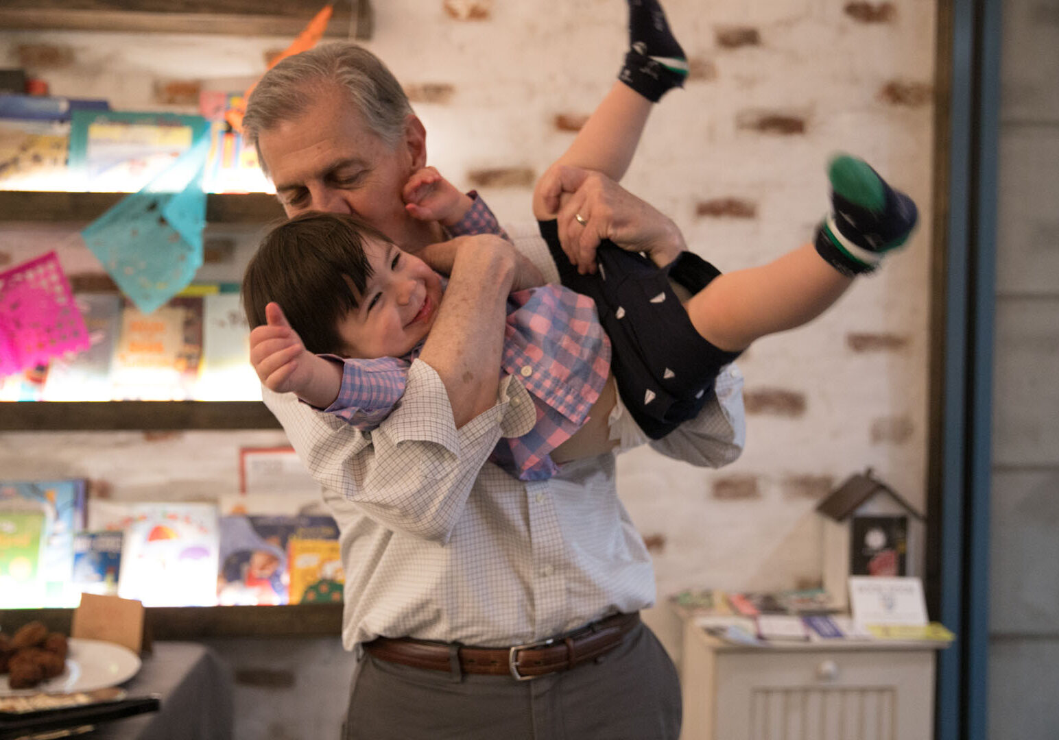 Father "flying" his son like an airplane holding him around the chest