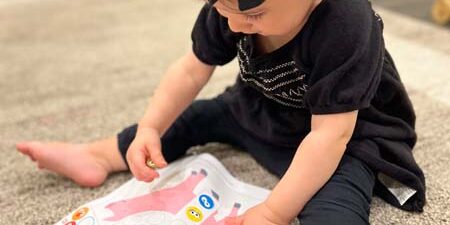 toddler playing with an activity book